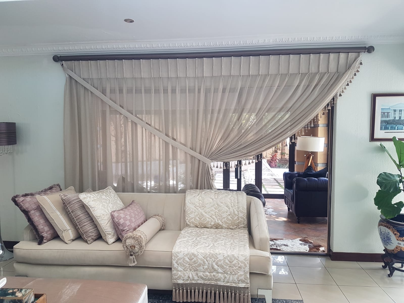 A softly lit lounge with custom curtains and layered textures by Designer Flair.